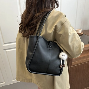 Minimalist black faux leather underarm tote bag with a cute white plush charm for women