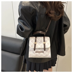 Detail of the chic checkered square crossbody bag with dog illustration and leather strap