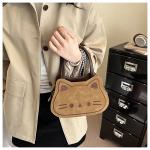 Detail of a brown cat-shaped mini handbag with embroidered whiskers and leather handle