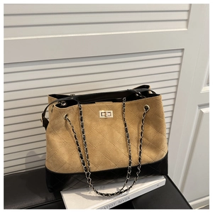 Detail of khaki suede tote bag with black quilted leather base and chain strap