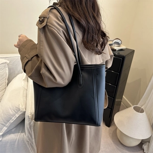 Retro black matte leather tote bag for women shown worn with a khaki trench coat