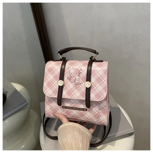 Close-up of pink plaid mini backpack featuring a cartoon dog and brown handles