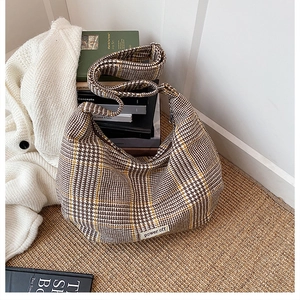 Detail of vintage plaid hobo bag with power off patch on woven mat background