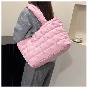 Close-up of pink quilted tote bag showing large square stitching and wide strap detail