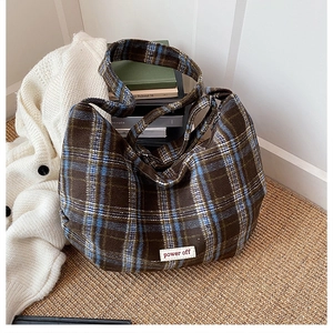 Macro detail of retro tartan canvas tote bag with woven power off label on fabric