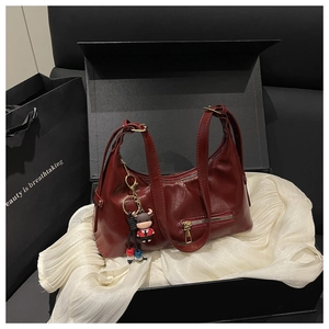 Deep red leather handbag in a premium black gift box with a cute cartoon bull charm