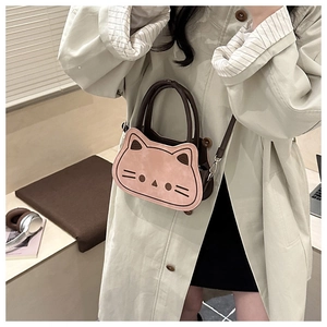 Detail of pink and brown cat-shaped crossbody bag with adjustable strap in a lifestyle set