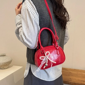 Red PU leather Boston bag with pearl bow and silver heart charm on a shoulder strap