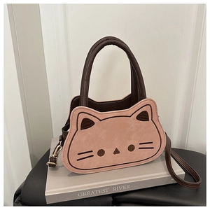 Detail of a cat-themed crossbody bag with brown frames and pink paneling and embroidery