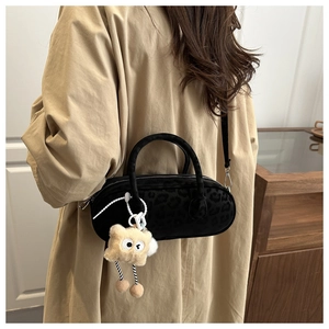 Detail of cylinder crossbody bag with leopard print and yellow star plush charm