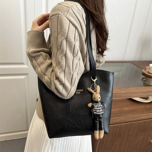 Chic black textured leather tote bag for women with stylish rabbit plush pendant accessory