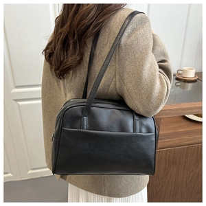 Detailed side view of black minimalist PU leather tote bag with exterior pocket details