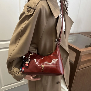 Deep red patent leather baguette bag with front gold zipper and cute calf charm