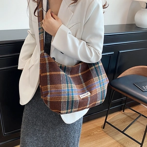 Vintage brown plaid tote bag with power off patch worn by model in stylish interior