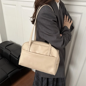 Minimalist beige PU leather tote bag with shoulder straps shown in a fashion lifestyle setting