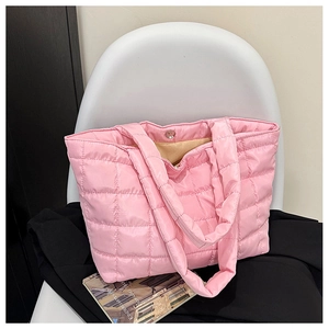 Detailed view of pink quilted tote bag with metallic magnetic buckle and glossy nylon finish