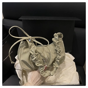 Detail of sage green ruched handbag with silver butterfly charm in premium gift box