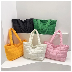 Detailed collection of quilted tote bags in five vibrant colors on display stands