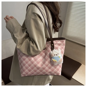 Pink and white checkered tote bag featuring a plush bear charm and brown leather straps