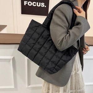 Chic black quilted puffer tote bag for women featuring modern oversized square stitching