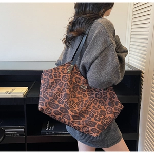 Close-up of leopard print tote bag with metallic lock and black leather shoulder strap