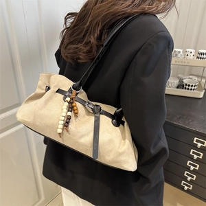 Retro beige suede shoulder bag with black leather straps and decorative beads