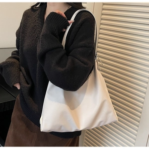 Close-up of minimalist white tote bag showing soft matte texture and seamless stitching