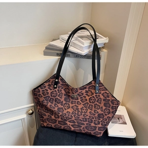 Detail of leopard print tote bag with gold swivel lock and reinforced black shoulder straps