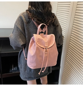 Detail of dusty pink textured backpack with flap closure and drawstring on model