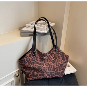Close-up of leopard print tote bag with metal buckle on a minimalist interior setting