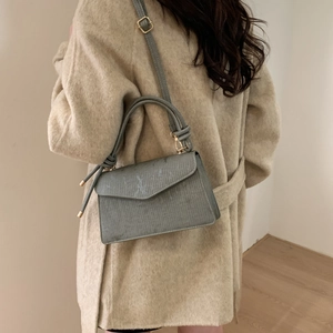Elegant grey textured crossbody bag with round handle and adjustable strap for women