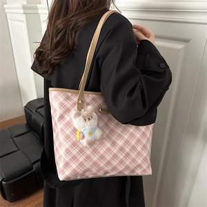 Pink checkered large tote bag with teddy bear pendant shown on female model shoulder