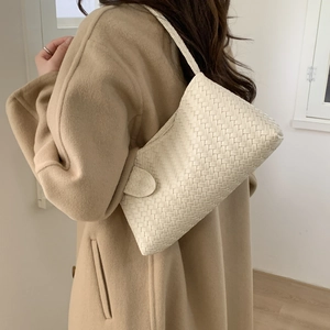 Sac bandoulière en cuir tressé blanc crème pour femme porté avec un manteau en laine