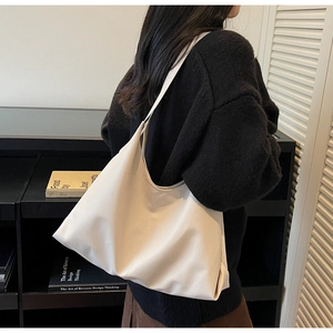 Chic cream white hobo shoulder bag worn by model with an oversize black sweater
