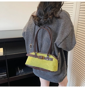 Detailed look at the avocado green suede handbag with retro buckle and brown leather strap