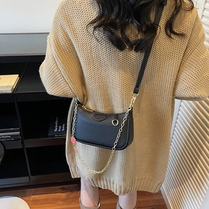 Sac demi-lune chic en cuir noir avec deux bandoulières porté par un mannequin en salle