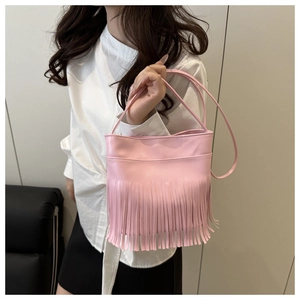 Detailed side view of pink tassel shoulder bag with elegant fringe and long handles