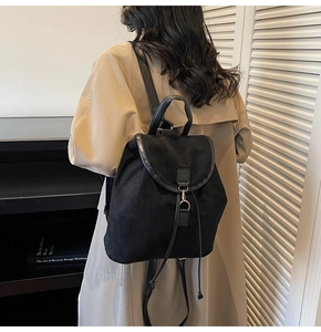 Detailed view of a black drawstring backpack with metal ring buckle on a female model