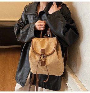 Detail of camel faux suede backpack featuring brown leather trim and vintage metal clasp