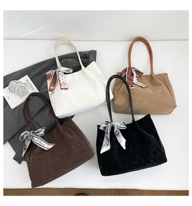 Macro detail of pleated tote bags with silk scarf handles in diverse neutral tones