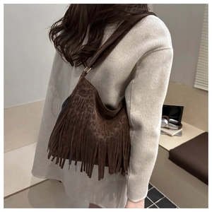 Detail of dark brown leopard print crossbody bag with stylish fringe and matte suede finish