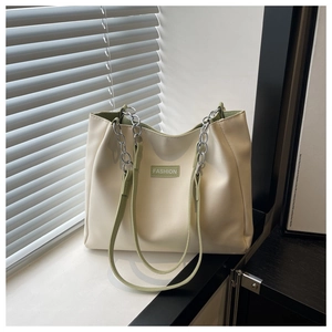 Detail of cream and green tote bag showing the FASHION label and chain leather strap
