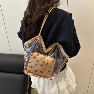 Transparent PVC cherry print tote bag with inner pouch shown on shoulder for size
