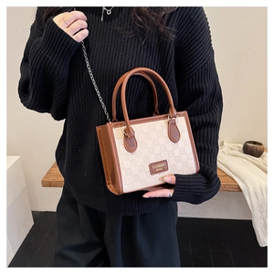 Détail du sac à damier crème avec bordure en cuir marron et chaîne dorée