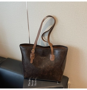 Detailed view of the dark brown retro tote bag with vintage leather texture and logo