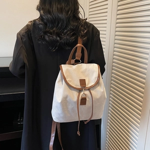 Chic retro canvas and leather backpack for women shown on a model in a cozy indoor setting