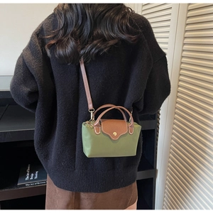 Model view of olive green crossbody bag with brown leather flap and retro gold buckle