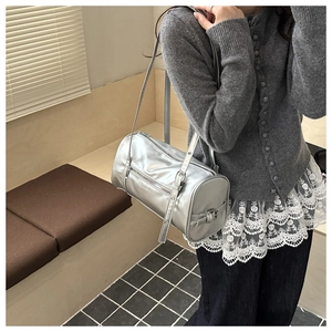 Vue portée d'un sac cylindre argenté métallisé avec bandoulière réglable pour femme