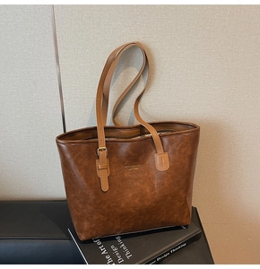 Detail of vintage brown tote bag with metal buckles and fashion leather branding