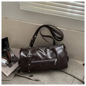 Close-up of a dark brown cylinder tote bag with glossy leather and silver hardware details